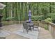 Spacious wooden deck with outdoor dining area, grill, and serene views of the surrounding greenery at 505 Bracken Edge, Peachtree City, GA 30269