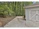 Long concrete driveway leads to a two-car garage with a wooded area visible beyond the garage at 505 Bracken Edge, Peachtree City, GA 30269