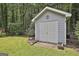 Well-maintained storage shed featuring a double door entrance and decorative architectural details in backyard at 505 Bracken Edge, Peachtree City, GA 30269