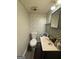Cozy half bathroom with elegant wallpaper, grey tile, and a stylish vanity at 375 Leisure Sw Ct, Marietta, GA 30064