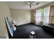 Spacious bedroom featuring a ceiling fan, natural light from the window, and dark carpeting at 375 Leisure Sw Ct, Marietta, GA 30064