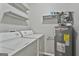 Laundry room equipped with washer, dryer, water heater, and overhead storage shelves at 292 Twiggs Cor, Peachtree City, GA 30269