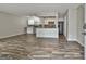 Open-concept living area with modern flooring and an adjacent kitchen featuring white cabinetry at 292 Twiggs Cor, Peachtree City, GA 30269