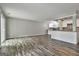 Spacious living room with modern flooring and a kitchen featuring white cabinetry and stone backsplash at 292 Twiggs Cor, Peachtree City, GA 30269