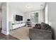 Cozy living room with plush gray sofa, media console, and ample natural light from the window at 1685 Tabor Dr, Marietta, GA 30062