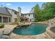 Expansive backyard featuring a custom pool, waterfall, lush landscaping and exterior home elevation at 4030 River Ridge Chase Se, Marietta, GA 30067