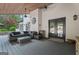 Covered patio with a cozy seating area, mini-fridge, and access to the landscaped backyard at 4030 River Ridge Chase Se, Marietta, GA 30067