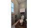Charming powder room with a white toilet, cabinet and a window providing natural light at 100 Rabbits Run, Fayetteville, GA 30214