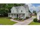 Charming two-story home features a welcoming porch, lush landscaping, and an American flag at 100 Rabbits Run, Fayetteville, GA 30214