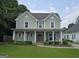 Charming two-story home featuring a welcoming front porch and manicured landscaping at 100 Rabbits Run, Fayetteville, GA 30214