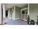 Charming covered front porch with columns, a hanging swing, and patriotic decor at 100 Rabbits Run, Fayetteville, GA 30214