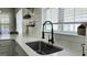 A close-up of the kitchen sink and countertop features a modern black faucet and decor at 100 Rabbits Run, Fayetteville, GA 30214