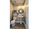 Rustic powder room features wood-look accent wall, pedestal sink, and charming decor at 100 Rabbits Run, Fayetteville, GA 30214