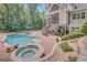 Expansive backyard showcasing a pool, hot tub, screened porch, and manicured landscaping for outdoor enjoyment at 265 Beverly Farms Dr, Sharpsburg, GA 30277