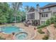 Expansive backyard view with swimming pool, hot tub, patio, lush landscaping, and exterior elevation at 265 Beverly Farms Dr, Sharpsburg, GA 30277