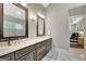 Bathroom featuring marble tile, double vanities, framed mirrors, and an adjacent bedroom at 265 Beverly Farms Dr, Sharpsburg, GA 30277