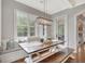 Cozy breakfast nook with bench seating, farmhouse table, and bright window overlooking lush greenery outside at 265 Beverly Farms Dr, Sharpsburg, GA 30277