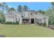 Stunning gray home featuring a stone entryway, manicured lawn, and lush landscaping at 265 Beverly Farms Dr, Sharpsburg, GA 30277
