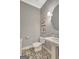 Stylish half bathroom featuring patterned tile floor, pedestal sink, and modern lighting fixtures at 265 Beverly Farms Dr, Sharpsburg, GA 30277