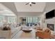 Open-concept living room with fireplace, built-in shelving, and seamless flow to the kitchen and screened-in porch at 265 Beverly Farms Dr, Sharpsburg, GA 30277
