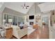 Open living room with fireplace, built-in shelving, high ceilings, and sliding doors to the screened-in porch at 265 Beverly Farms Dr, Sharpsburg, GA 30277