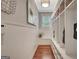 This mudroom has hardwood floors, a light fixture, white wainscoting, a window, and built in storage at 265 Beverly Farms Dr, Sharpsburg, GA 30277