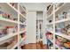 Spacious walk-in pantry with ample shelving and hardwood flooring to maximize storage space at 265 Beverly Farms Dr, Sharpsburg, GA 30277