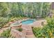 Beautiful pool and spa area surrounded by lush landscaping, creating a serene backyard oasis at 265 Beverly Farms Dr, Sharpsburg, GA 30277