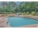 Outdoor pool surrounded by beautiful landscaping and lush greenery for relaxation and enjoyment at 265 Beverly Farms Dr, Sharpsburg, GA 30277