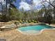 This swimming pool features a stone retaining wall, mature trees, and a basketball hoop at 265 Beverly Farms Dr, Sharpsburg, GA 30277