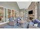 Bright sunroom with a stone fireplace, comfortable seating, and easy access to outdoor living spaces at 265 Beverly Farms Dr, Sharpsburg, GA 30277