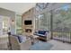 Cozy sunroom with stone fireplace, comfortable seating, and expansive views of the serene backyard at 265 Beverly Farms Dr, Sharpsburg, GA 30277