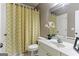 Bright bathroom features a patterned shower curtain, vanity, mirror, and toilet with easy access to the door at 931 Hidden Falls Se Ln, Smyrna, GA 30082