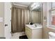 Well-lit bathroom features a vanity, mirror, patterned shower curtain, and toilet for everyday convenience at 931 Hidden Falls Se Ln, Smyrna, GA 30082