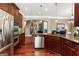 Open-concept kitchen with stainless steel appliances, dark wood cabinetry, a kitchen island, and hardwood floors at 931 Hidden Falls Se Ln, Smyrna, GA 30082