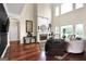 Sun-drenched living room boasts hardwood floors, a stone fireplace, soaring ceilings, and large windows with backyard views at 931 Hidden Falls Se Ln, Smyrna, GA 30082