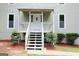 Inviting front porch with bright white stairs, railing and trimmed bushes at 3858 Trenton Dr, Snellville, GA 30039