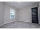 Neutral bedroom featuring soft carpet, a window with blinds, and a black door at 309 Dean Ct, Temple, GA 30179