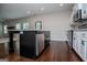 A kitchen with stainless steel appliances, black island, and white cabinets enhances the appeal of the space at 309 Dean Ct, Temple, GA 30179