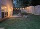 Cozy backyard patio illuminated with string lights, offering a serene outdoor space for relaxation and enjoyment at 2938 Cottesford Se Way, Smyrna, GA 30080