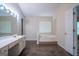 Bathroom with a soaking tub, vanity, and a window offering natural light at 2938 Cottesford Se Way, Smyrna, GA 30080
