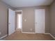 Bedroom view showcasing an open door and another closed door with neutral carpeting at 2938 Cottesford Se Way, Smyrna, GA 30080