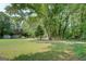 Expansive backyard featuring mature trees and storage sheds on a large grassy lawn at 315 Jewel Ln, Covington, GA 30014