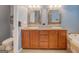 Bathroom featuring double sinks, decorative mirrors, tile floors, and toilet at 315 Jewel Ln, Covington, GA 30014