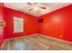 Red bedroom with wood floors, ceiling fan, closet, mounted TV and bright walls at 315 Jewel Ln, Covington, GA 30014