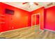 Red bedroom with wood floors, ceiling fan, closet, shelves and mounted TV at 315 Jewel Ln, Covington, GA 30014