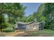 Rear exterior with mature trees, showing a well-maintained house with backyard patio and adjacent lawn at 315 Jewel Ln, Covington, GA 30014