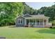 Charming single-story home with a covered porch, gray siding, and a well-manicured lawn surrounded by lush greenery at 315 Jewel Ln, Covington, GA 30014