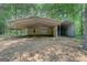Exterior view of a metal outbuilding featuring covered parking and gated area for storage at 315 Jewel Ln, Covington, GA 30014
