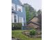 Charming blue home featuring white trim, front yard landscaping, and a brick retaining wall at 2540 Picardy N Cir # B, South Fulton, GA 30349